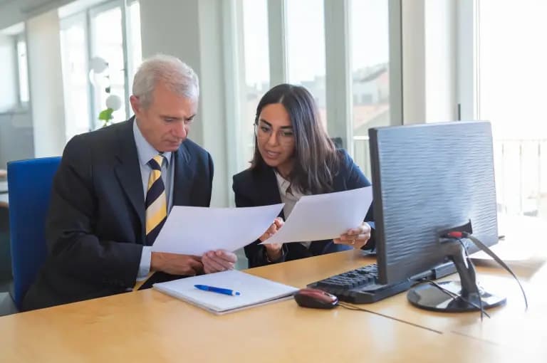 Dois advogados analisando papéis em uma mesa