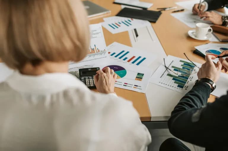 Grupo de pessoas em uma mesa realizando cálculos empresariais